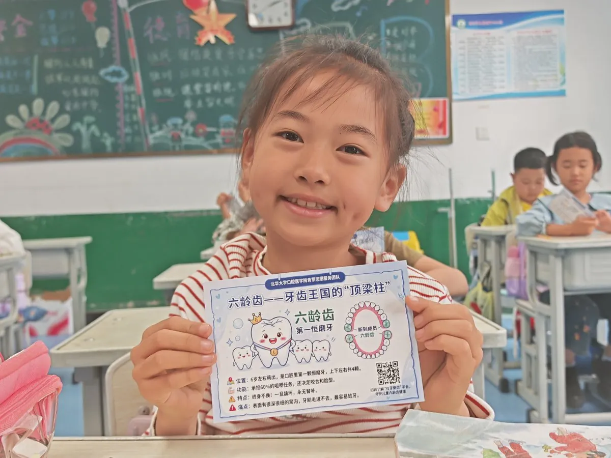 孩子展示印有班级二维码的六龄齿科普明信片